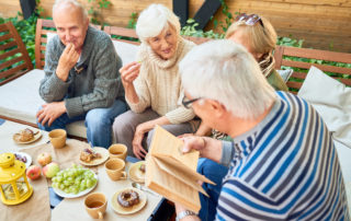 A group of senior friends enjoying a meal outdoors