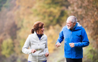 A happy, active senior couple out on a run together