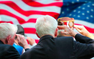 A group of senior veterans saluting the American flag