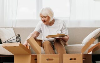 A senior woman packing up boxes to prepare to move to a senior living community