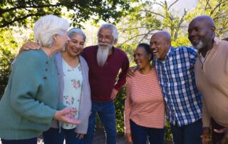 Group of senior friends outdoors laughing and talking about independent living options for seniors