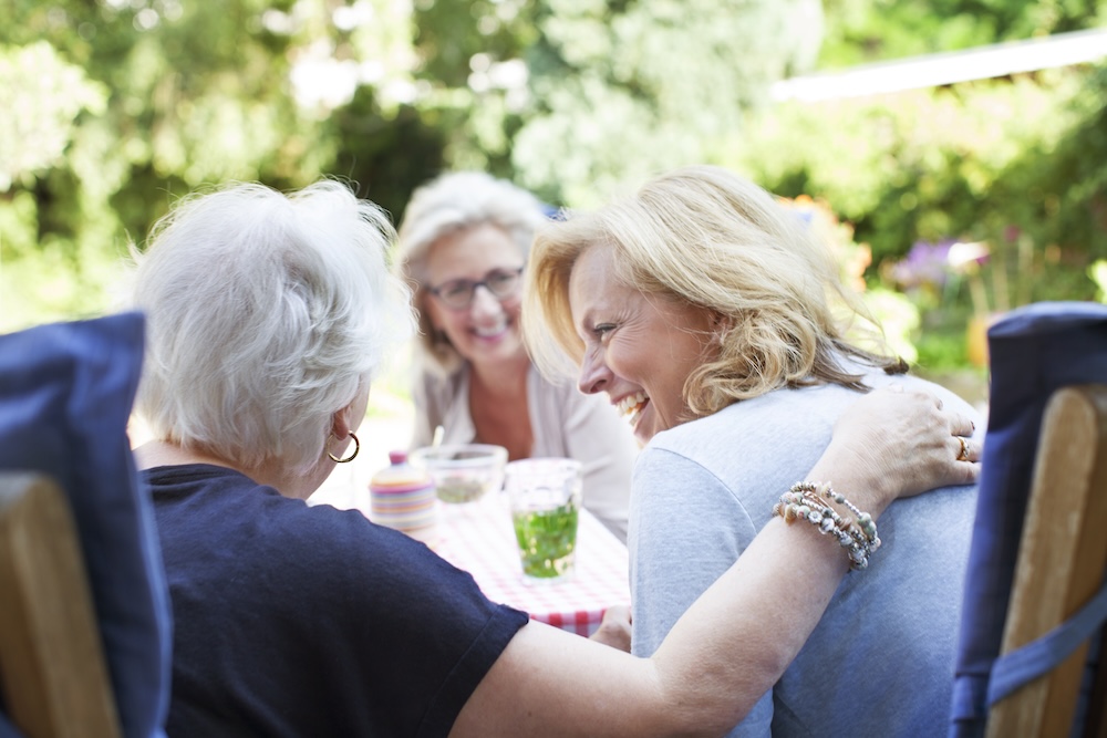 Three senior women at their senior living communities enjoying the outdoors together